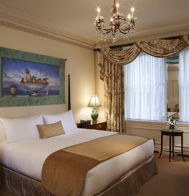 Rest easy in a king size bed under an ornate chandelier while staying in Interior Suite #815.