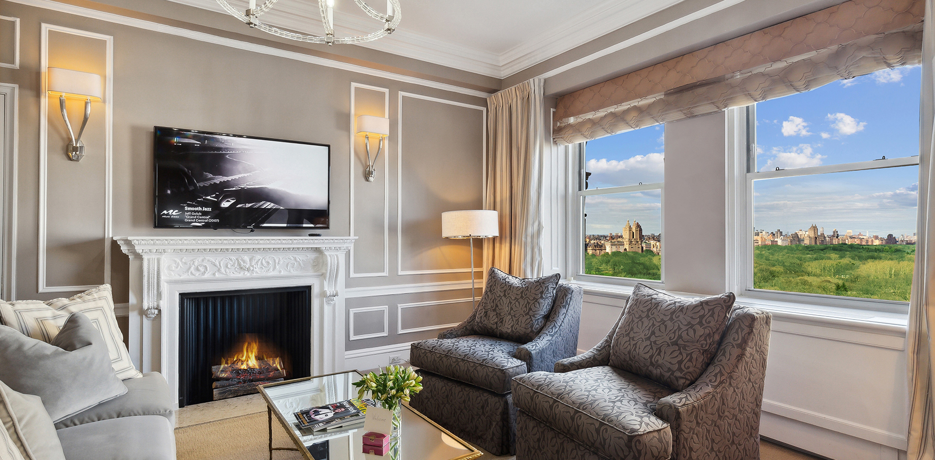 Elegant living room suite at The Sherry-Netherland with Central Park views, fireplace, and classic furnishings