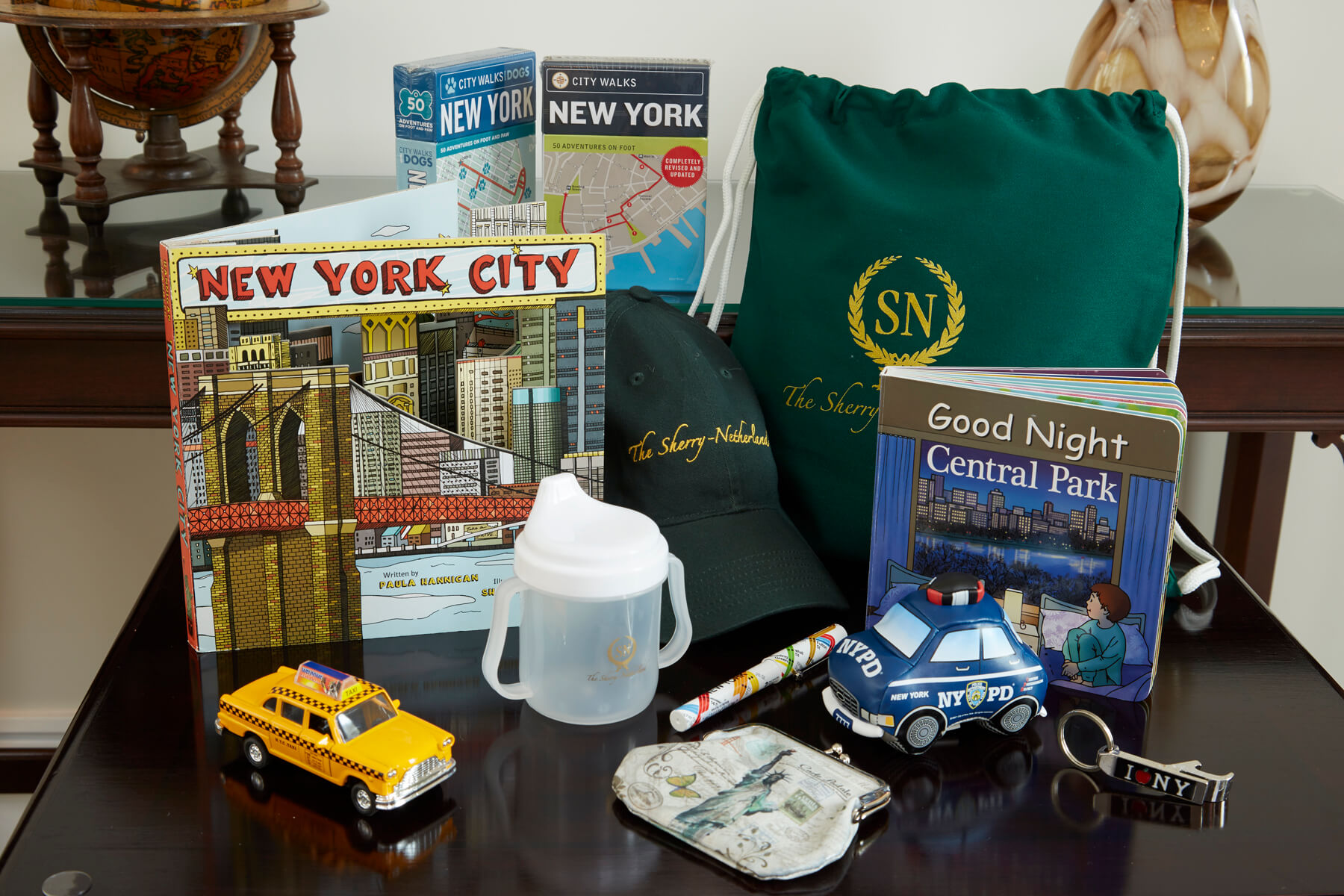 Children’s amenities at The Sherry-Netherland, including NYC books, toys, a cup, and a branded drawstring bag