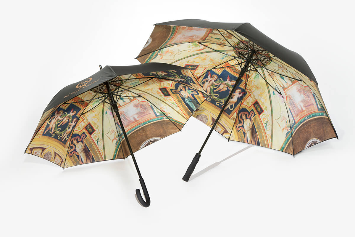 Two black umbrellas with vibrant interior canopies depicting the ornate painted ceiling from The Sherry-Netherland lobby.